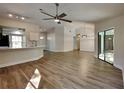 Spacious living area with fan, wood-look floors, and open views to kitchen at 213 Almaden Ct, Winter Springs, FL 32708