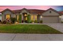 Well-maintained single-story home with a red tile roof, manicured landscaping, and a brick driveway at 2359 Baronsmede Ct, Winter Garden, FL 34787
