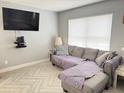 Inviting living room with a comfortable gray couch, tv, and tile floors at 3024 Natoma Way, Orlando, FL 32825