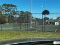 Community tennis courts are surrounded by a fence and set against a backdrop of trees and a clear sky at 4251 Pinebark Ave # 17-3, Orlando, FL 32811