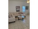 Bright living room with a neutral sectional, tile floors, white walls and decorative wall art at 4573 Ada Ln, Kissimmee, FL 34746