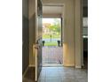 View from the tiled entryway looking out to a brick paved driveway, planters and front yard at 4783 Riverwalk Dr, St Cloud, FL 34771