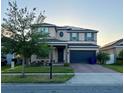 Well-manicured two-story home with solar panels, brick driveway, and attached two car garage at 4783 Riverwalk Dr, St Cloud, FL 34771