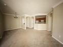 Spacious living room with neutral carpet, crown molding, and an open view into the kitchen and dining nook at 8276 Maritime Flag St # 201, Windermere, FL 34786