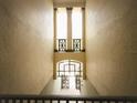 Open stairwell with natural light streaming through glass doors and geometric railings on a multi-level building at 8276 Maritime Flag St # 201, Windermere, FL 34786