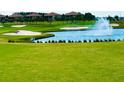 Picturesque golf course view with lush green grass, water feature, sand traps, and well-maintained landscaping at 8908 Azalea Sands Ln, Davenport, FL 33896