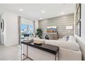 Bright living room with a comfortable sofa, large window, and modern accent wall at 921 Pearlwood Loop, Eagle Lake, FL 33839