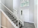 Bright foyer featuring high ceilings, staircase, and a large window for natural light at 101 Sandpebble Pl, Sanford, FL 32771