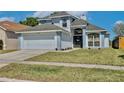 Charming two-story home features a two-car garage, manicured lawn, and inviting front entrance with decorative wreath at 12613 Maribou Cir, Orlando, FL 32828