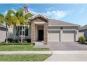 Inviting home featuring a stone facade, well-maintained lawn, and a convenient two-car garage at 1807 Good Neighbor Loop, Kissimmee, FL 34744