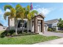 Inviting home exterior with palm trees, stone accents, and a manicured lawn at 1807 Good Neighbor Loop, Kissimmee, FL 34744