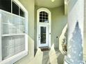Close up view of front door including side window and column, and classic architectural details under a bright blue sky at 2014 Applegate Dr, Ocoee, FL 34761