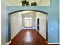 Cozy living room with hardwood flooring, and inviting archway with plants above leading to another room at 2014 Applegate Dr, Ocoee, FL 34761