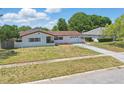 Lovely single-story home with white brick, red roof, driveway, and landscaped front yard at 2240 Archer Blvd, Orlando, FL 32833