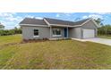 Single-story home with a well-manicured lawn, fresh landscaping, and a two-car garage at 23810 Sw Indian Hill Dr, Dunnellon, FL 34431
