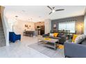 Open-concept living area with sleek tile flooring, modern furnishings, and a view of the kitchen at 2964 Protagonist St, Kissimmee, FL 34746