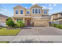 Inviting two-story home with a brick driveway and manicured landscaping under a blue sky at 3087 Somerset Park Dr, Orlando, FL 32824