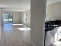 Open living space with tile flooring seamlessly connecting the living room and modern kitchen at 3513 Westland Dr, Orlando, FL 32818