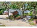 Well-maintained home with a circular driveway, lush landscaping, and mature trees creating a private setting at 420 Wild Oak Cir, Longwood, FL 32779