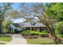 Beautiful home with mature trees, lush landscaping, a brick driveway and walkway leading to the front entrance at 420 Wild Oak Cir, Longwood, FL 32779