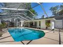 Inviting screened-in pool with clear blue water, surrounded by a spacious patio and lush greenery at 420 Wild Oak Cir, Longwood, FL 32779