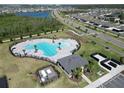 Aerial view of a community pool with a lake and surrounding neighborhood in the background at 4316 Carrabelle River Ln, Lakeland, FL 33811