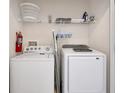 Convenient laundry area with washer, dryer, shelving, and fire extinguisher at 4500 Alberto Cir, Kissimmee, FL 34746