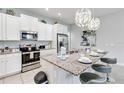 Kitchen with island, granite countertops, stainless appliances and three barstools at 482 Captiva Dr, Davenport, FL 33836