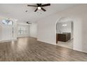 Spacious living room with wood floors, archways, and views into the kitchen and entryway at 5335 Coral Vine Ln, Kissimmee, FL 34758