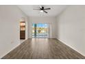 Open-concept living area with wood floors and sliding glass doors leading to a patio at 5335 Coral Vine Ln, Kissimmee, FL 34758