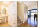 Bright entryway features hardwood floors, stairs, closet, and powder room with pedestal sink and decorative mirror at 6274 Bristol Channel Way, Orlando, FL 32829