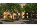 View of townhome nestled among trees and a landscaped yard at 6364 Raleigh St # 1615, Orlando, FL 32835