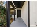 Covered front porch with black trim, white siding, and gray flooring is a cozy spot to enter the home at 6713 Cherry Rd, Ocala, FL 34472
