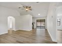 Bright living room with light wood floors, neutral walls, ceiling fan and view of the back patio at 6713 Cherry Rd, Ocala, FL 34472
