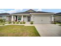 Charming home with a two-car garage, manicured lawn, and a welcoming front porch at 8043 Brookeshire Dr, Lakeland, FL 33809