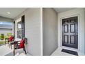A welcoming porch features comfortable seating and a stylish front door, creating a cozy entrance at 8043 Brookeshire Dr, Lakeland, FL 33809
