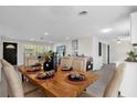 Well-lit dining room adjacent to kitchen, featuring a wooden table set for elegant dining at 822 Oakview Dr, New Smyrna Beach, FL 32169