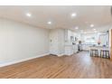 Bright living room with vinyl floors opens to an updated kitchen with barstool seating and shelving space at 1000 Lake Of The Woods Blvd # 103H, Casselberry, FL 32730