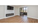 Modern living room featuring a TV, fireplace, wood floors, and sliding glass doors to porch at 1000 Lake Of The Woods Blvd # 103H, Casselberry, FL 32730