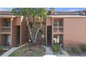 An exterior view showing the condo complex, stairways, mature trees, and well-kept grounds at 1092 E Michigan St # 1, Orlando, FL 32806