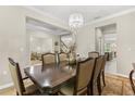 Refined dining room with stylish chandelier, view into the living room, and seating for eight at 12002 Angle Pond Ave, Windermere, FL 34786