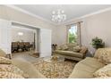 Inviting living room featuring an ornamental chandelier and opening up to an adjacent dining room at 12002 Angle Pond Ave, Windermere, FL 34786