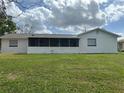 This property boasts a back exterior view with a large screened in porch and spacious backyard at 1328 Highland Cir, Kissimmee, FL 34744