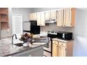 Kitchen featuring granite countertops, stainless steel appliances, and natural wood cabinets at 1400 Lake Shadow Cir # 10105, Maitland, FL 32751