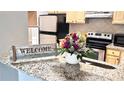 Open kitchen featuring granite countertops, stainless steel appliances, and natural wood cabinets at 1400 Lake Shadow Cir # 10105, Maitland, FL 32751