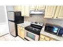 Updated kitchen features stainless steel appliances, granite countertops, and natural wood cabinets at 1400 Lake Shadow Cir # 10105, Maitland, FL 32751