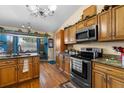 Traditional-style kitchen featuring wood cabinetry, granite countertops, and modern stainless steel appliances at 1969 La Rue Ave, Deltona, FL 32725