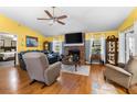 Cozy living room featuring a brick fireplace, hardwood floors, and abundant natural light at 1969 La Rue Ave, Deltona, FL 32725
