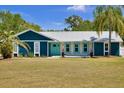 Inviting home with blue siding, decorative stone accents, and a manicured lawn at 245 Country Circle E Dr, Port Orange, FL 32128