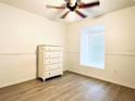 Neutral bedroom featuring wood-look floors, and a large window with pleated shades at 2651 Andros Ln, Kissimmee, FL 34747